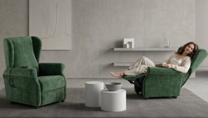 Donna seduta su poltrona relax Bergè Compact verde con funzione alzapersona e doppio motore presso Tino Mariani